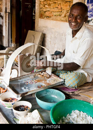 Vertical portrait of a man grinding gemstones by hand in Sri Lanka. Stock Photo
