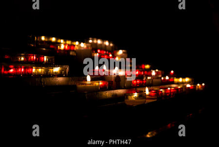 Bright lights of burning candles in the darkness of Christian church Stock Photo