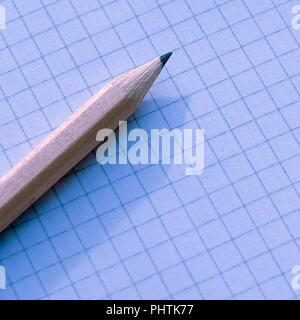 the pencil on the Notepad. Notebook sheet in a cage Stock Photo
