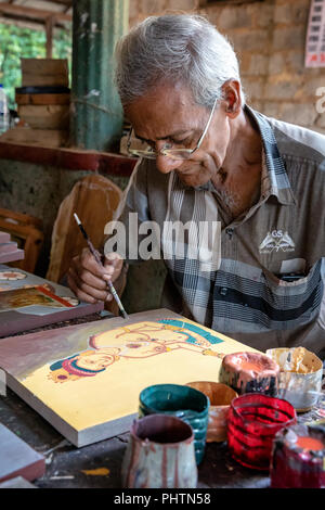 A male artist painting a replica of the famous wall paintings at Sigiriya, Anuradhapura, Sri Lanka Stock Photo