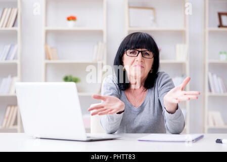 Senior woman struggling at computer Stock Photo