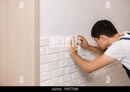 Professional Builder gluing decorative tile on wall. Stock Photo