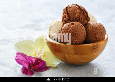Vanilla and chocolate ice cream balls in a wooden bowl. Stock Photo
