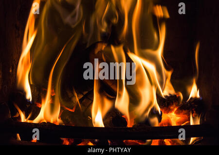 Coal fire and log engulfed with flames burning in a grate Stock Photo