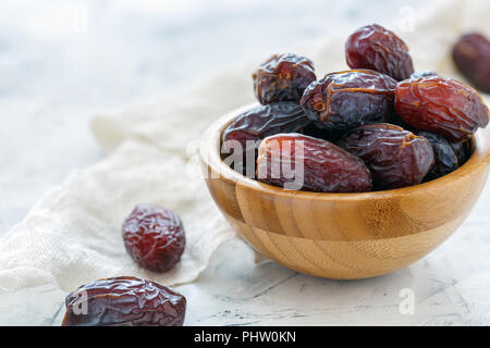 Dried fruits of date palm in a wooden bowl. Stock Photo