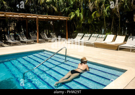 Woman relaxing in an exclusive swimming pool at a caribbean hotel Stock ...