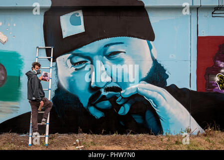 Street artist at work on a portrait of American reality TV star Action Bronson at Marine Parade in Leith, Edinburgh, Scotland, UK. Stock Photo