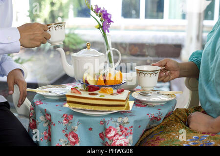 Asian business people having tea and cake and fresh fruit Stock Photo