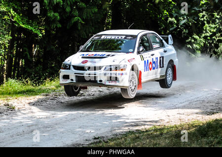Mitsubishi Lancer EVO IX rally car racing on the special forest stage at the Goodwood Festival of Speed. Jumping. Airborne. Flying. Rob Gill driver Stock Photo