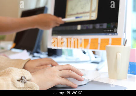women in office working together on desktop Stock Photo
