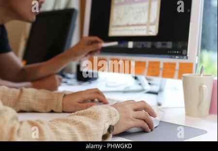 women in office working together on desktop Stock Photo