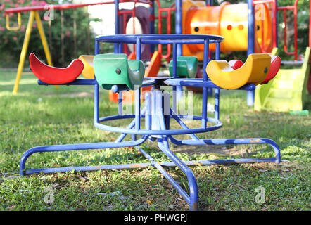 Colorful roundabout with yellow chairs in empty child playground Stock Photo