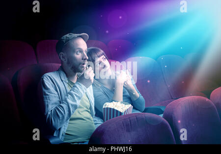 Teenager couple cuddling and watching the climax part of the movie Stock Photo