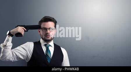 Young lost businessman man shooting his head with gun Stock Photo