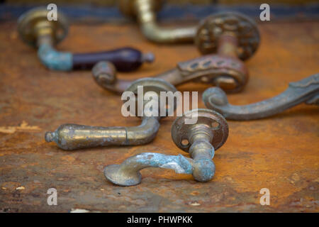old metal door handles on rusty table top Stock Photo