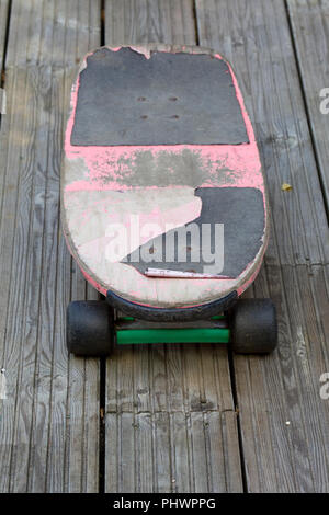 Old used skateboard on exterior decking Stock Photo