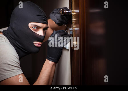 Burglar wearing balaclava mask at crime scene Stock Photo