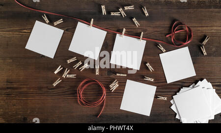Blank frames of photo, rope and clothespins on wood background. Flat lay. Stock Photo