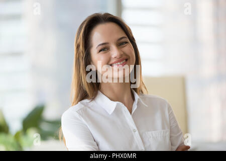 Happy smiling millennial businesswoman looking at camera in offi Stock Photo