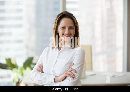 Smiling confident businesswoman looking at camera in office, hea Stock Photo