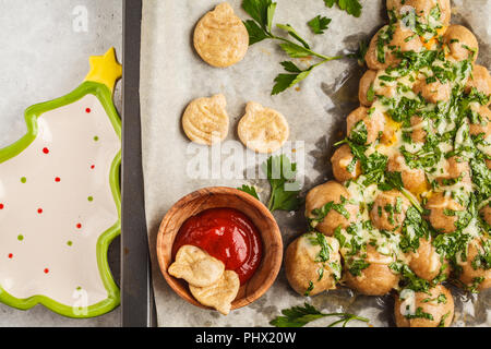Christmas tree cheese pizza with greens on a baking sheet, top view. Christmas food concept. Stock Photo