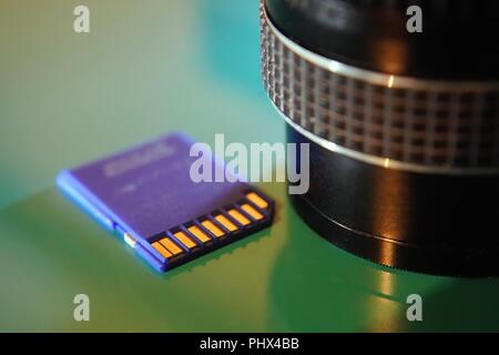 Multimedia SD Card and camera lens close up Stock Photo