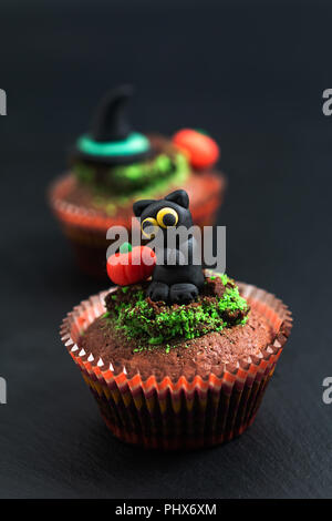 Halloween Holiday food colorful fancy brownies cupcake with black cat and pumpkin fondant decorate Stock Photo