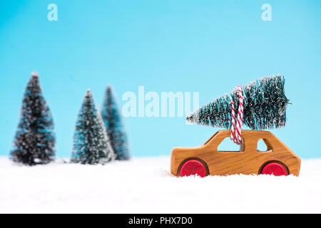 Wooden toy car carrying Christmas tree. Stock Photo