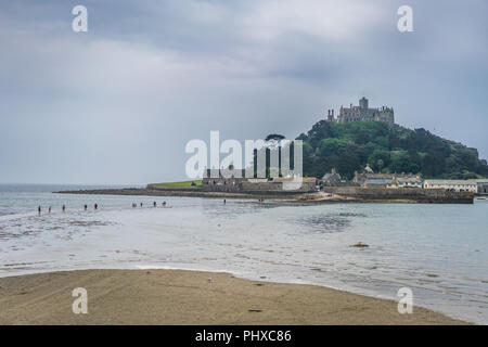 Marazion, England -  May 2018 : People walking on a footpath leading to the St Michaels Mount during low tide, Cornwall