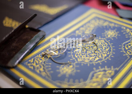 Close up of bespoke book covers and old spectacles at a book binder Stock Photo