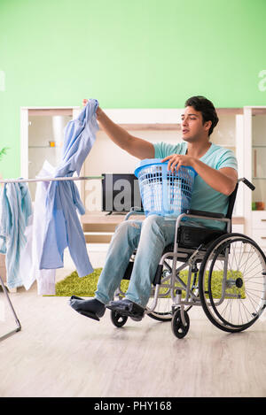 Disabled man on wheelchair doing laundry Stock Photo