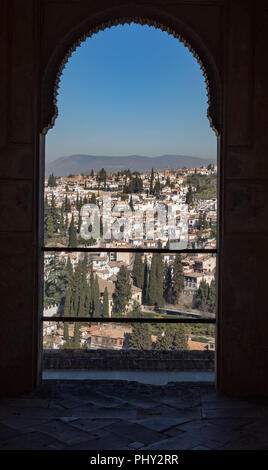 Cityscape of Granada, Spain on a sunny summer morning seen through Arab style arched window Stock Photo