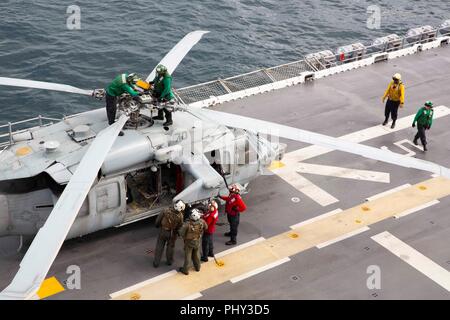 180828-N-JN023-0320 ATLANTIC OCEAN (Aug. 28, 2018) Sailors perform pre-flight checks on a MH-60S Sea Hawk on the flight deck of the Wasp-class amphibious assault ship USS Kearsarge (LHD 3) prior to flight operations during the Carrier Strike Group FOUR (CSG 4) Amphibious Ready Group, Marine Expeditionary Unit Exercise (ARGMEUEX). Kearsarge Amphibious Ready Group and 22nd Marine Expeditionary Unit are enhancing joint integration, lethality and collective capabilities of the Navy-Marine Corps team through joint planning and execution of challenging and realistic training scenarios. CSG 4 mentors Stock Photo
