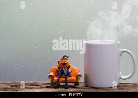 Halloween festival Head Doll Pumpkins  haunted spooky with Steaming coffee cup decoration on wood table. Blank space available for text. Stock Photo