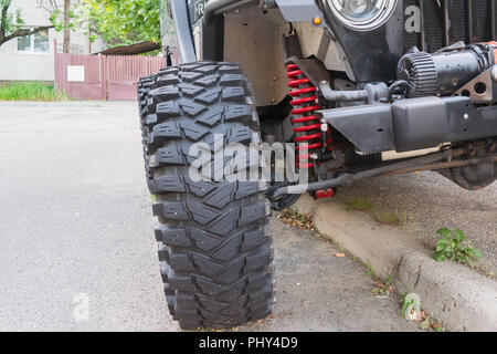 detail of offroad vehicle showing big tire and red coil suspension Stock Photo