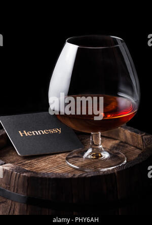 LONDON, UK - SEPTEMBER 04, 2018: Glass of Hennessy Cognac with original coaster on top of wood. Stock Photo