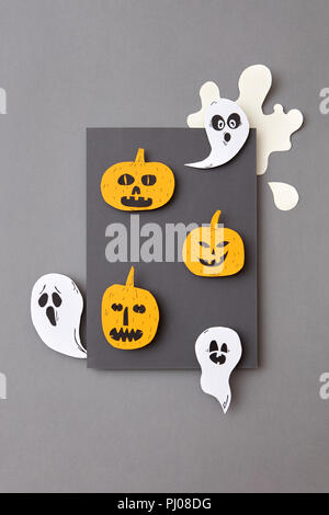 Happy Halloween. Square frame of flying floating, ghosts spirits and smiling yellow pumpkins on a gray background. Stock Photo