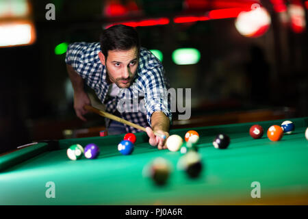 Young attractive man playing pool in bar Stock Photo