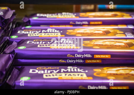 London, UK - August 12, 2018 - Pile of Cadbury chocolate bars on display at a duty free shop in London Heathrow Airport Stock Photo