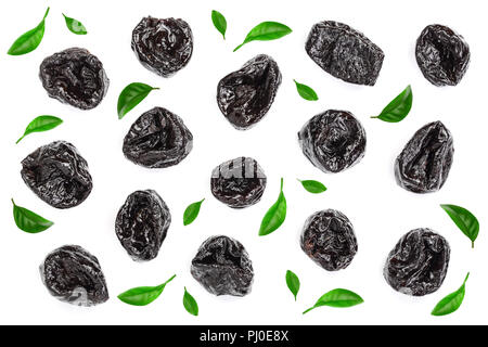 Dried plum - prunes decorated with green leaves isolated on a white background. Top view. Flat lay Stock Photo