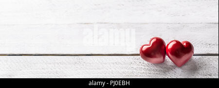 Two red hearts on wooden table. Romantic panoramatic banner for valetines or wedding day. Stock Photo