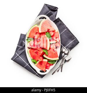 Sliced watermelon berry, fresh fruit on plate with napkin and forks. Group of objects isolated on white background clipping path included. Top view, f Stock Photo