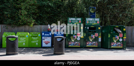 Reading, United Kingdom - August 06 2018:   Charity Recycling bins in the car park of Napier Road Tesco, including shoes, Books, DVDs, Clothes, given  Stock Photo