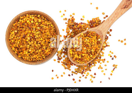 fresh bee pollen in wooden spoon and bowl isolated on white background. Top view. Flat lay. Stock Photo
