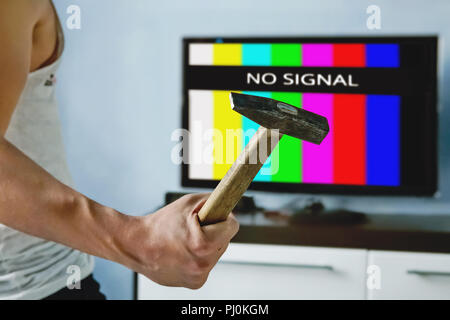 viewer is furious with the problems with broadcasting. Multi-colored stripes on the TV screen. The inscription on the TV NO SIGNAL. televiewer wants t Stock Photo