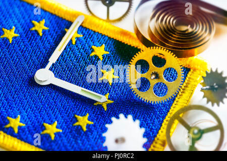 Watch hands and gear wheels on EU flag, end of changing clocks in the EU Stock Photo