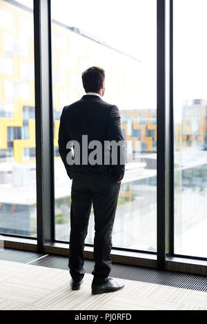 Pensive Businessman by Window Stock Photo