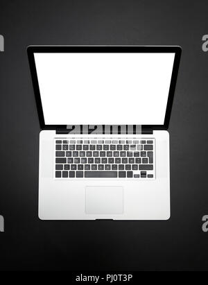 Modern laptop device from above on black table. Clipping path for laptop and screen Stock Photo