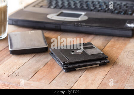 diskette on blur coffee in cup and blur notebook background, Stock Photo