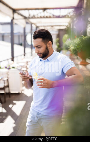 Handsome Middle-Eastern Man Using Smartphone Stock Photo